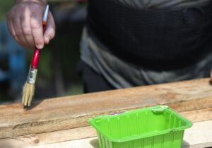 homem pintando com verniz para madeira